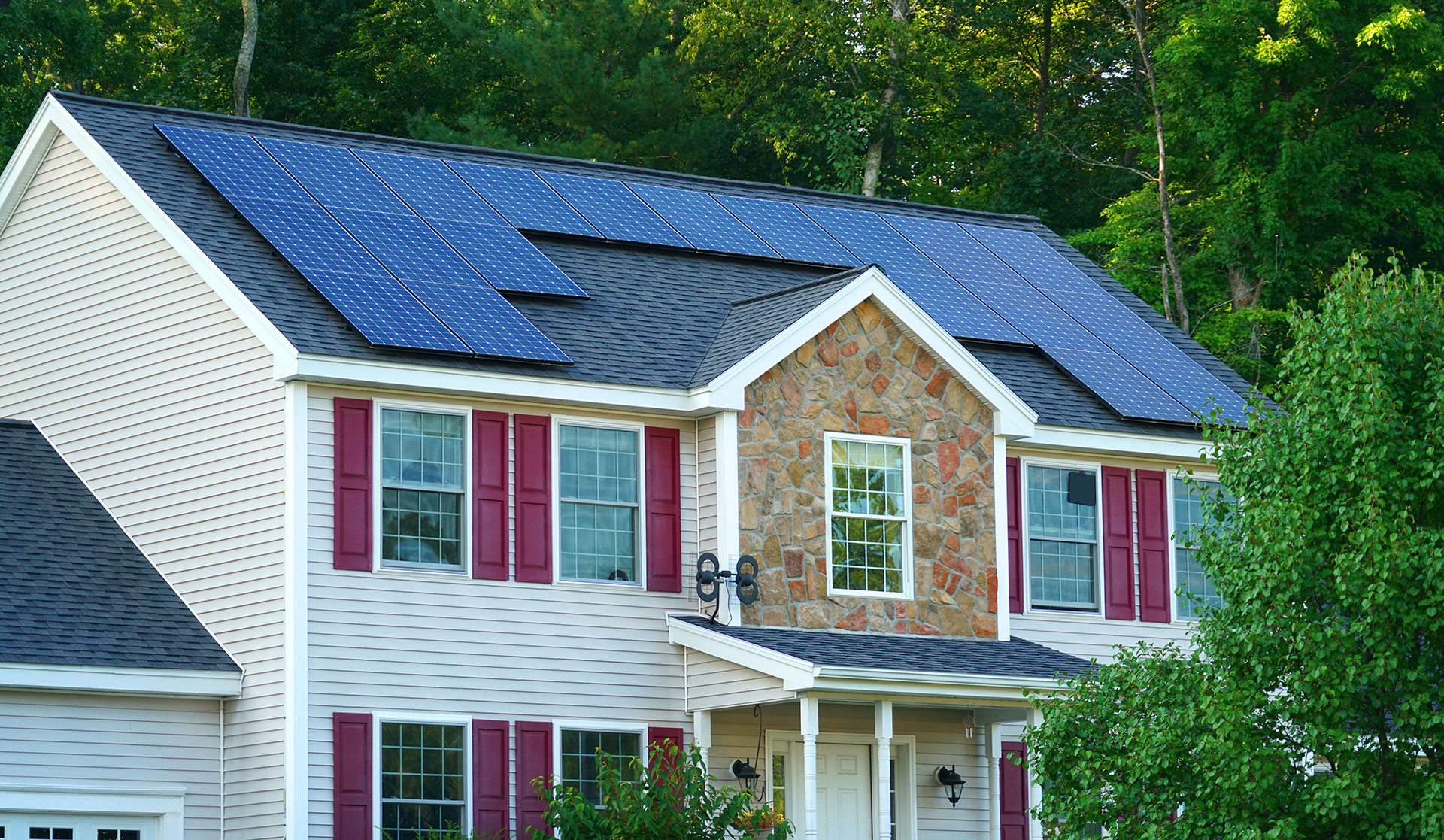 A large suburban home with solar panels on the roof