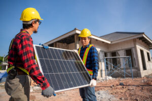 Two technicians are carrying solar cells for installation