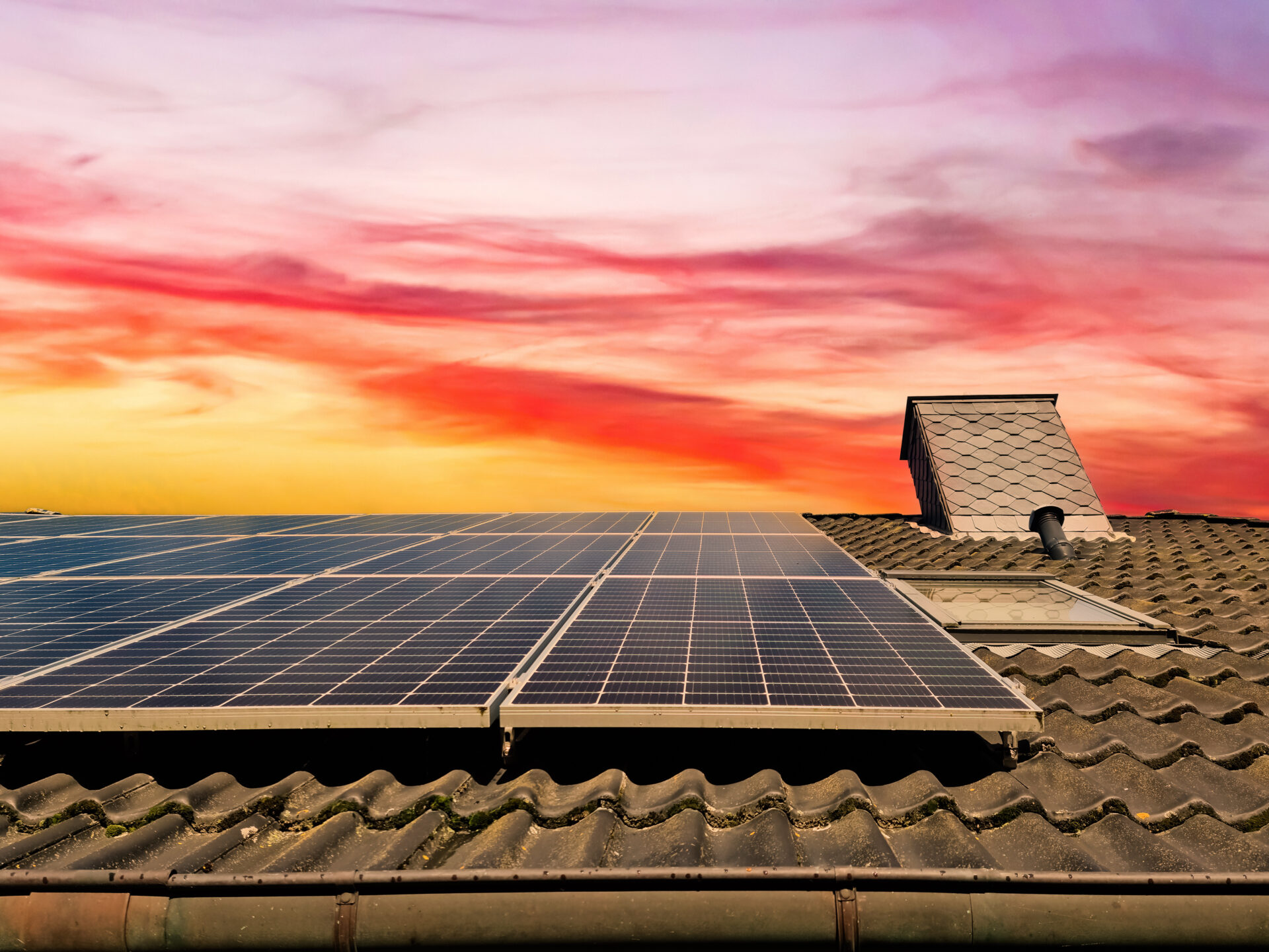 Solar panels on top of a roof at sundown